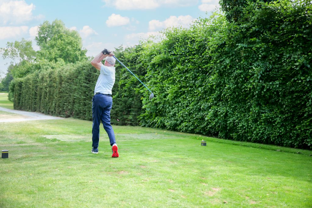Golfer drives off the tee during the 41st Annual CWRF Charity Golf Day at Moor Park Golf Club, raising funds for children’s welfare and research.