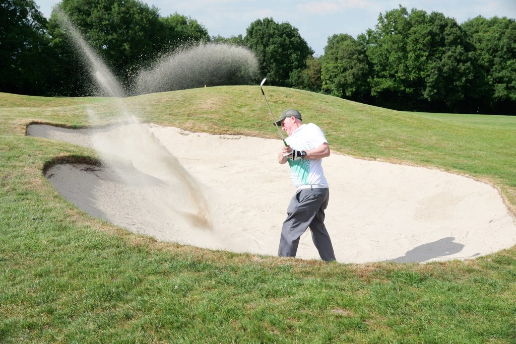 Golfer plays a bunker shot during the 41st Annual CWRF Charity Golf Day at Moor Park Golf Club, raising funds for children’s welfare and research.